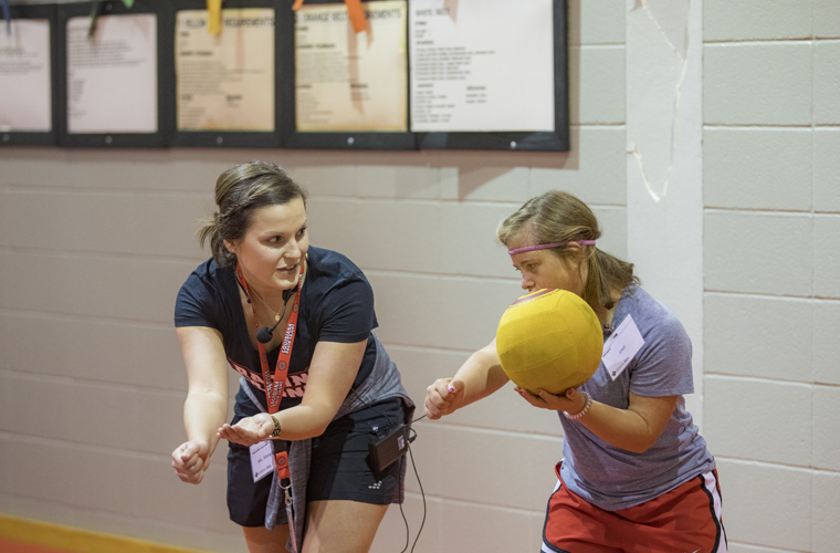 Kinesiology teaching child to serve volleyball 